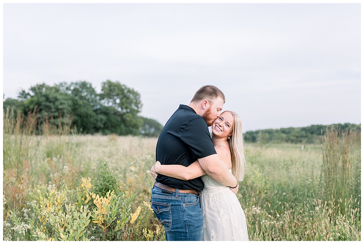 couple kissing in field shawnee mission park engagement