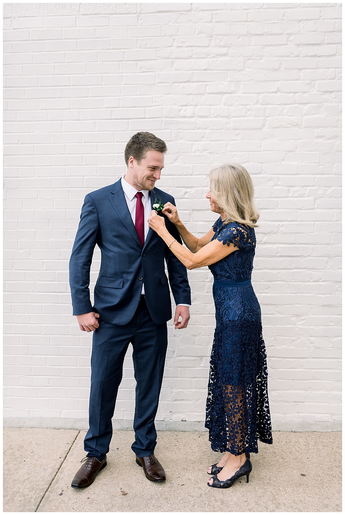 groom with mother pinning on boutonnierre